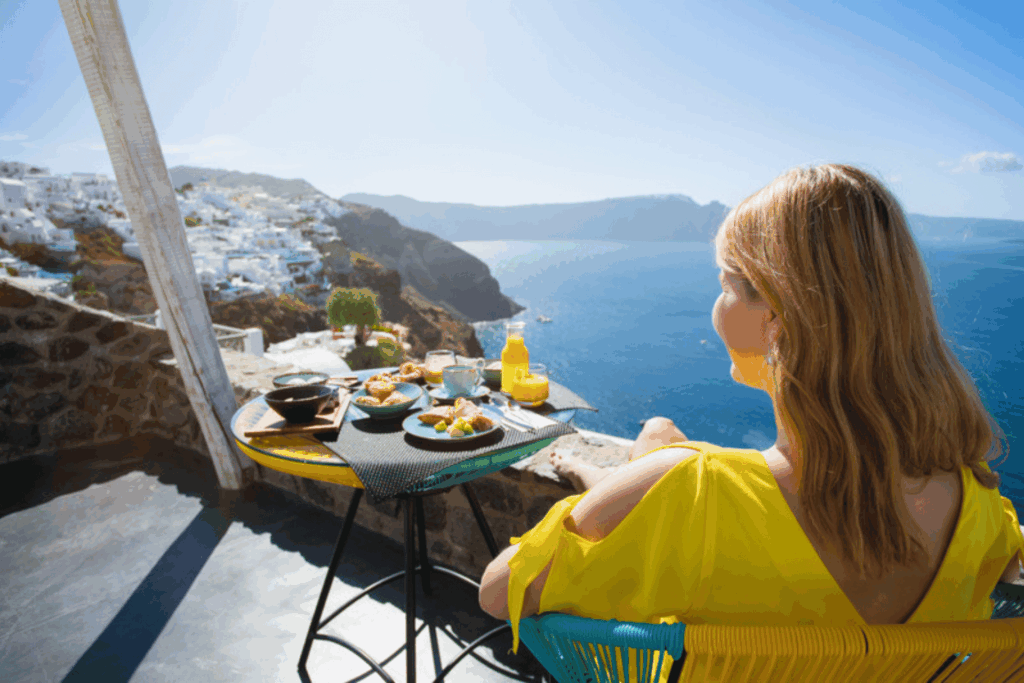 Woman having breakfast on a hotel terrace with a sea view