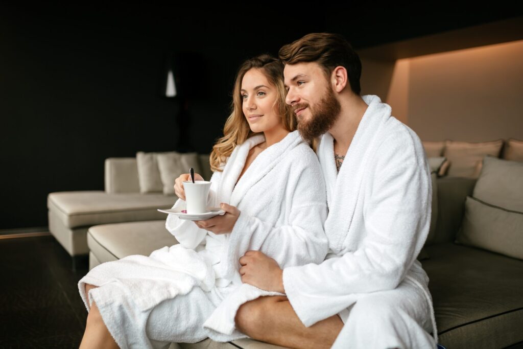 Couple in bathrobes relaxing in a hotel spa lounge