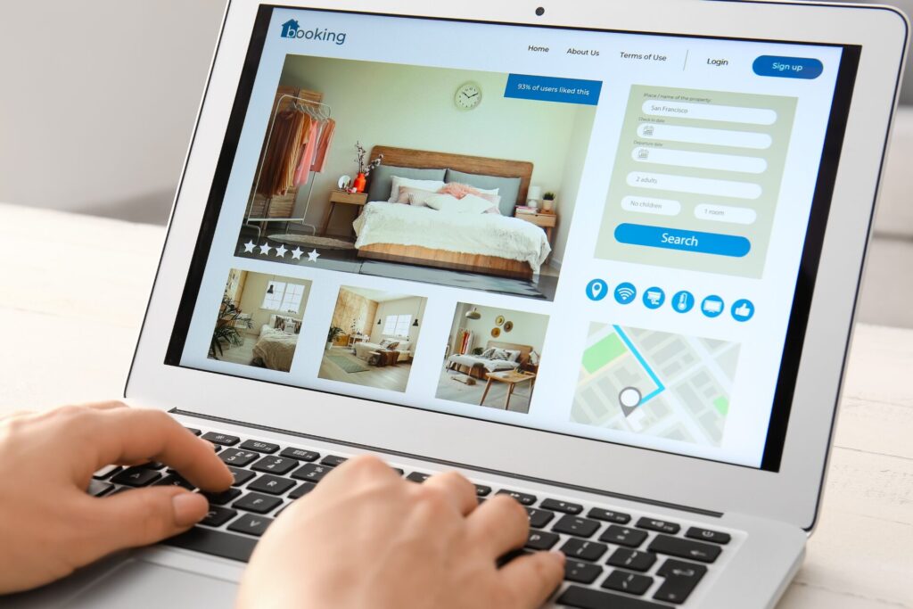 Person typing on a laptop showing a hotel booking page