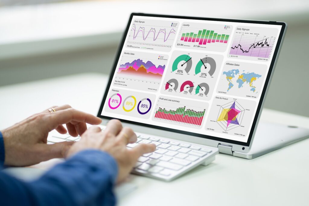 Person working on a laptop with marketing analytics charts on screen